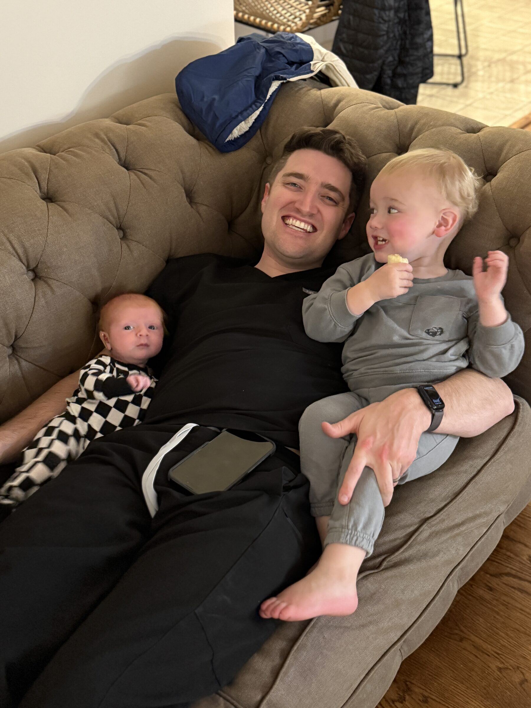 Dr. R.J. Stuart relaxing on the couch at home with his two young children, Richie and baby Mary Kate.