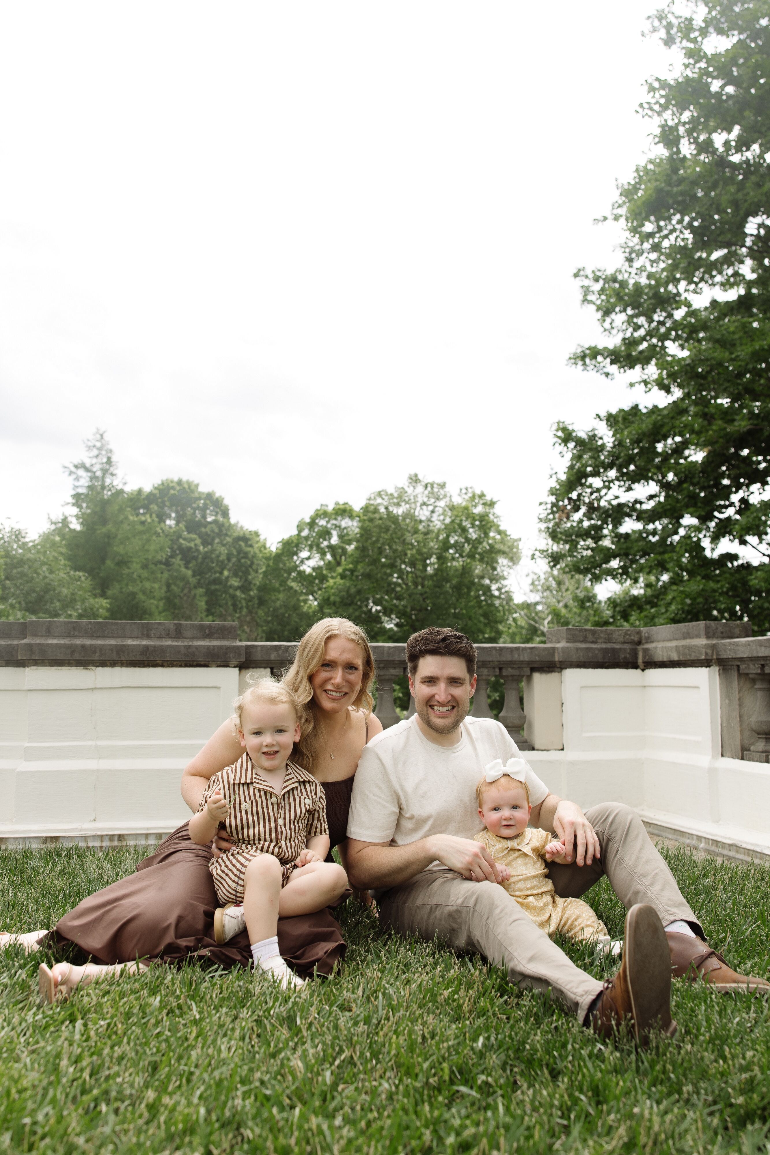 The Stuart family - Dr. R.J. Stuart, his wife Kathleen, their son Richie, and baby daughter Mary Kate - sitting together on the grass.
